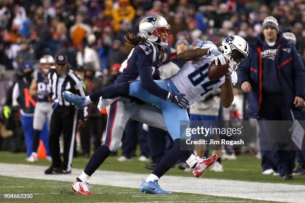 Corey Davis of the Tennessee Titans attempts to hold on to a catch against Stephon Gilmore of the New England Patriots in the first half in the AFC...