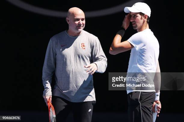 Tennis legend Andre Agassi gives some tips to Novak Djokovic of Serbia during a practice session ahead of the 2018 Australian Open at Melbourne Park...
