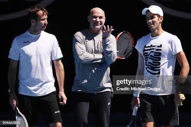 Tennis legend Andre Agassi gives some tips to Novak Djokovic of Serbia during a practice session ahead of the 2018 Australian Open at Melbourne Park...