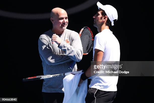 Tennis legend Andre Agassi gives some tips to Novak Djokovic of Serbia during a practice session ahead of the 2018 Australian Open at Melbourne Park...