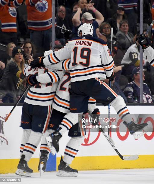 Patrick Maroon of the Edmonton Oilers jumps into teammates celebrating on the ice after Darnell Nurse scored an overtime goal against the Vegas...