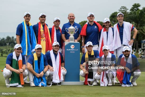 Team Europe's players pose for photographs with the trophy after winning the Eurasia Cup golf tournament at the Glenmarie Golf and Country club in...