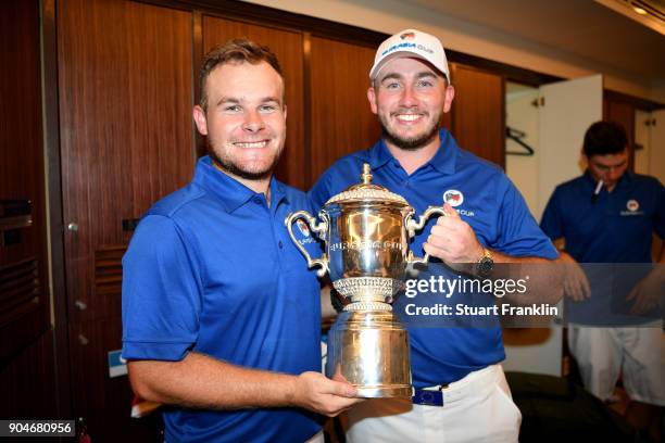 Tyrrell Hatton of Europe celebrates with the trophy and caddie Jonathan Bell following his team's victory during the singles matches on day three of...