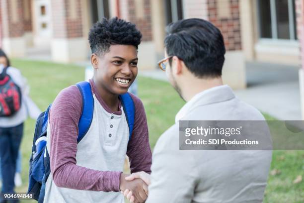 teenage boy receives congratulations from high school teacher - congratulating child stock pictures, royalty-free photos & images