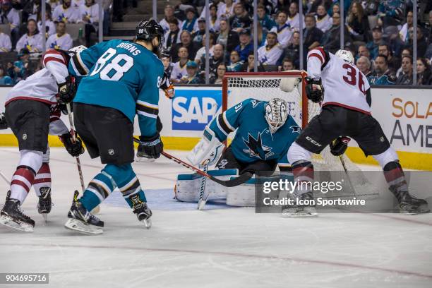 San Jose Sharks goaltender Martin Jones makes a save on Arizona Coyotes right wing Christian Fischer during the first period of the regular season...