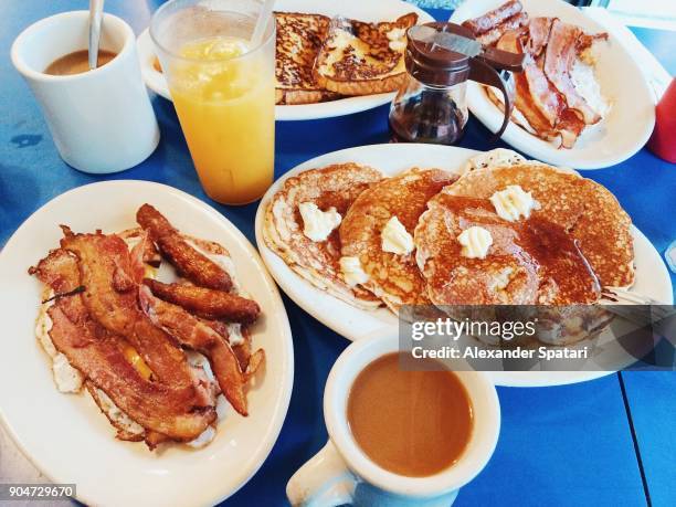 classic american breakfast with fried eggs, bacon, pancakes, maple syrup and coffee served in a diner - usa diner stock pictures, royalty-free photos & images