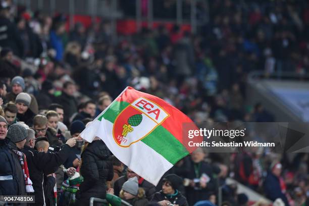 Supporter of Augsburg waves a flag during the Bundesliga match between FC Augsburg and Hamburger SV at WWK-Arena on January 13, 2018 in Augsburg,...