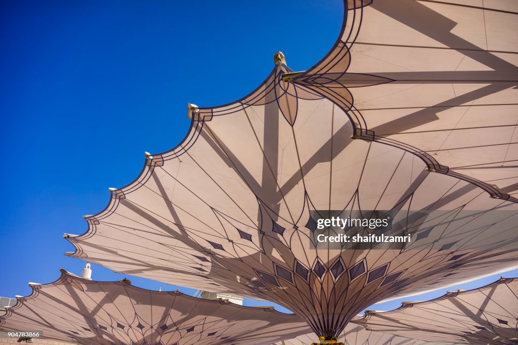 MEDINA, SAUDI ARABIA - 16TH NOV 2017; Morning view of minarets and big umbrellas of Nabawi Mosque. Nabawi mosque is the second holiest mosque in Islam and built in 622.