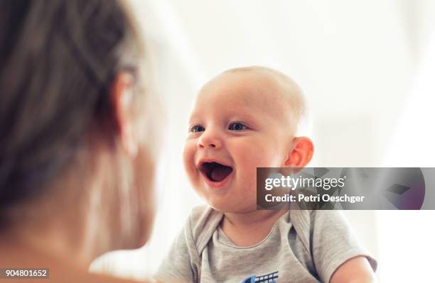 bonding with mom. - smiling baby stock pictures, royalty-free photos & images