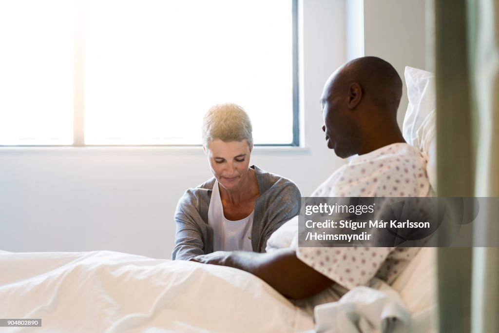 Femme assise par l’homme dans la salle d’hôpital lumineuses