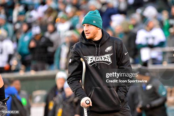 Philadelphia Eagles quarterback Carson Wentz appears on the field with a crutch before the NFC divisional playoff game between the Atlanta Falcons...