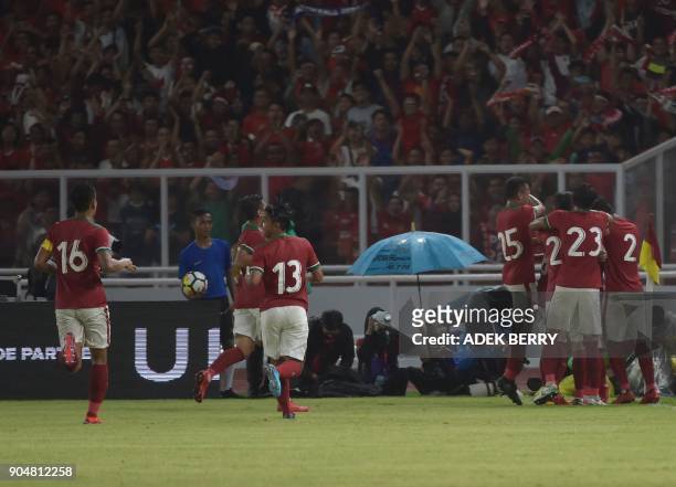 Indonesian team celebrate a goal as they play against Iceland during a friendly match in Jakarta on January 14, 2018. / AFP PHOTO / ADEK BERRY