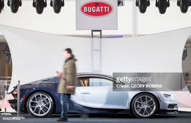 Journalist walks by a Bugatti Chiron on display at Cobo Hall before the 2018 North American International Auto Show in Detroit, Michigan, January 14,...