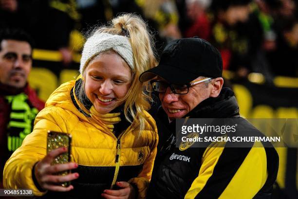 Dortmund's head coach Peter Stoeger poses for a selfie photo with a fan prior to the German first division Bundesliga football match BVB Borussia...