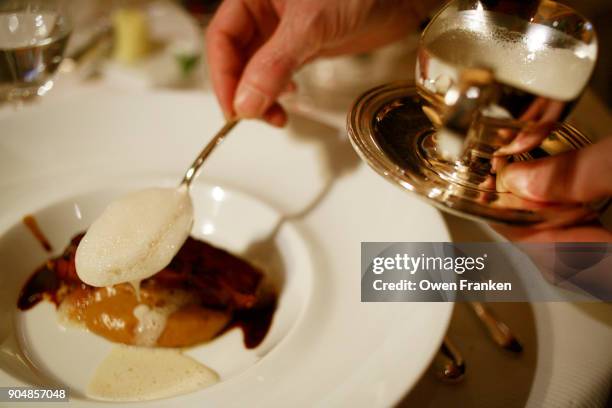 waiter saucing a dish at michelin three star  restaurant pierre gagnaire, paris - paris restaurant stock pictures, royalty-free photos & images
