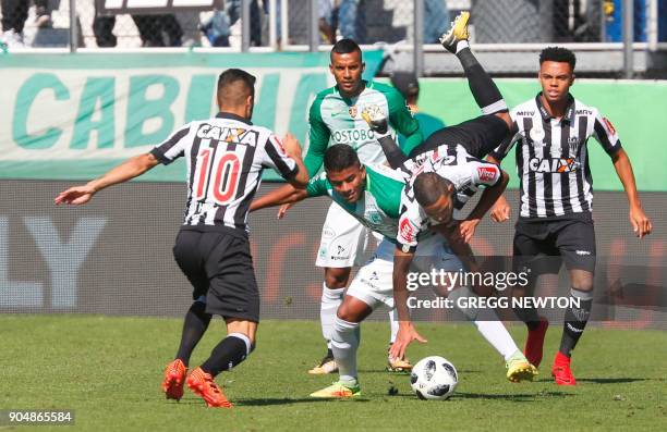 Adson of Brazilian club Atletico Mineiro is upended by Gustavo Torres of Colombian side Atletico Nacional during their Florida Cup soccer game at...