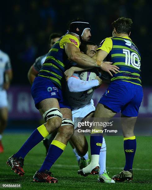 Jean-Marc Doussain of Toulouse is tackled by George Earle and Jarrod Evans of Cardiff Blues during the European Rugby Challenge Cup match between...