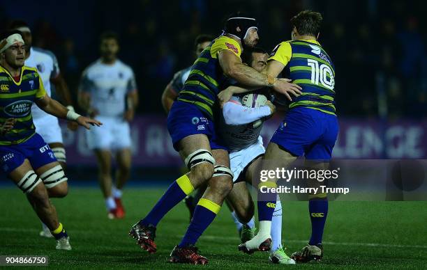 Jean-Marc Doussain of Toulouse is tackled by George Earle and Jarrod Evans of Cardiff Blues during the European Rugby Challenge Cup match between...