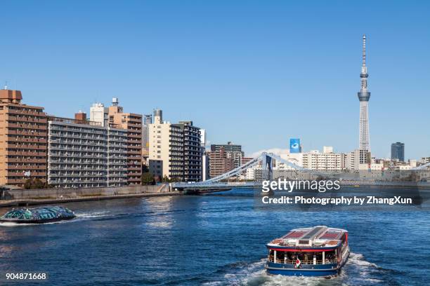 tokyo cityscape skyline with kiyosu bridge and houseboats over sumida river waterfront landscape at day time, tsukishima, chuo ward, tokyo, japan. - sumidafloden bildbanksfoton och bilder