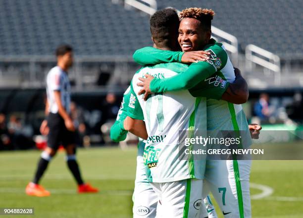 Andres Renteria of Colombian side Atletico Nacional gets a hug from teammate Gustavo Torres after scoring a goal against Brazilian club Atletico...
