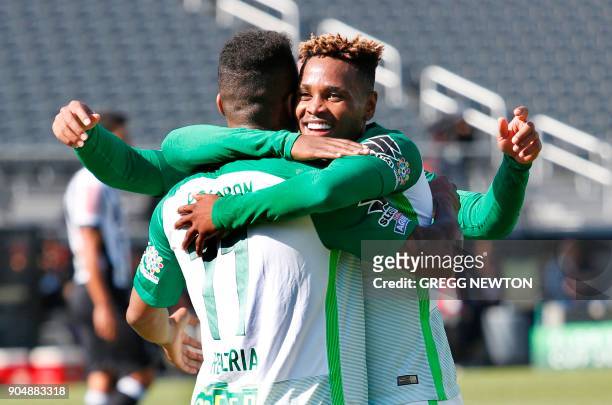 Andres Renteria of Colombian side Atletico Nacional gets a hug from teammate Gustavo Torres after scoring a goal against Brazilian club Atletico...