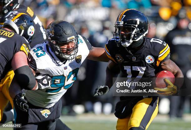Eli Rogers of the Pittsburgh Steelers runs up field against Calais Campbell of the Jacksonville Jaguars after a reception in the first half during...