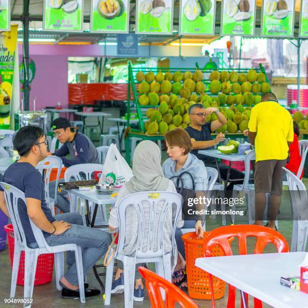 people are sitting down and enjoy durians - famous food programa de televisión fotografías e imágenes de stock