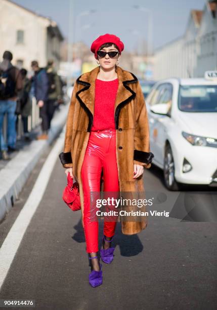 Eleonora Carisi wearing red vinyl pants, red flat cap, red bag, brown fur coat is seen outside DSquared2 during Milan Men's Fashion Week Fall/Winter...