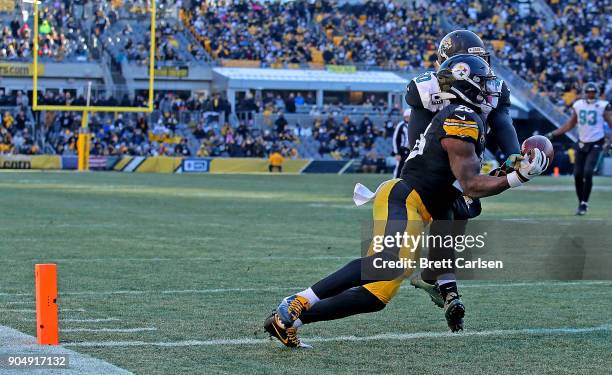 Le'Veon Bell of the Pittsburgh Steelers catches a pass in front of Telvin Smith of the Jacksonville Jaguars for a 19 yard touchdown reception in the...