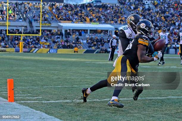 Le'Veon Bell of the Pittsburgh Steelers catches a pass in front of Telvin Smith of the Jacksonville Jaguars for a 19 yard touchdown reception in the...