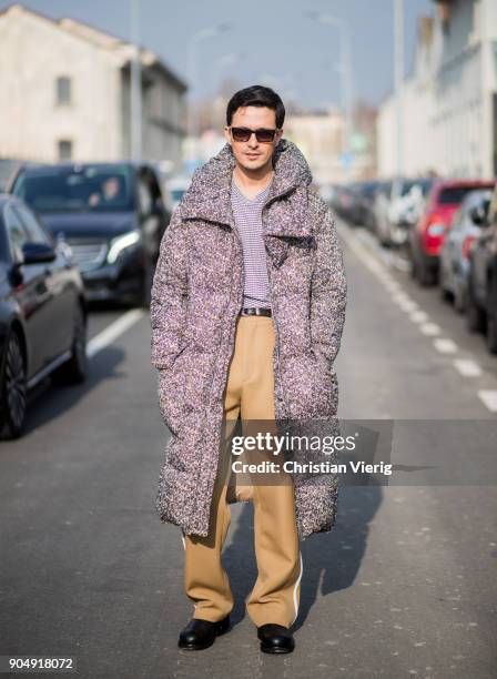 Alessandro Enriquez wearing down feather coat, beige pants is seen outside DSquared2 during Milan Men's Fashion Week Fall/Winter 2018/19 on January...