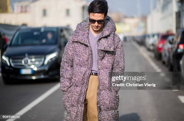 Alessandro Enriquez wearing down feather coat, beige pants is seen outside DSquared2 during Milan Men's Fashion Week Fall/Winter 2018/19 on January...