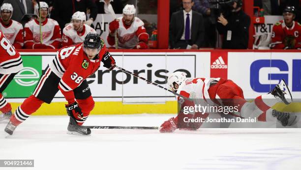 Luke Witkowski of the Detroit Red Wings hits the ice after tangling with Ryan Hartman of the Chicago Blackhawks at the United Center on January 14,...