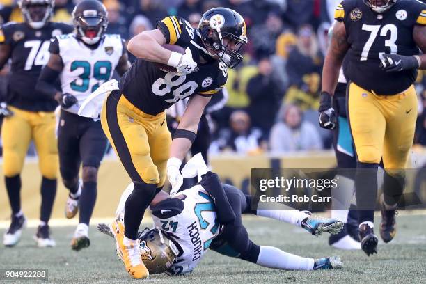 Vance McDonald of the Pittsburgh Steelers pushes off a tackle from Barry Church of the Jacksonville Jaguars during the second half of the AFC...