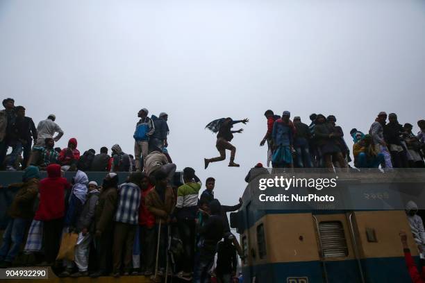 Commuter jumps between train's compartment upon arrival at a station, to attend Akheri Munajat, the final supplication during Biswa Ijtema in Tongi,...