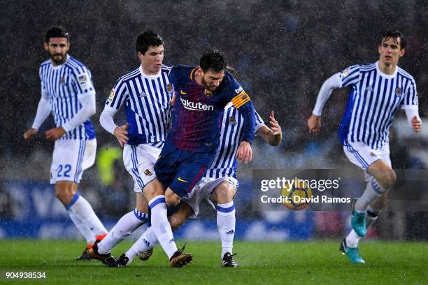 Lionel Messi of FC Barcelona is brought down by Igor Zubeldia and Asier Illarramendi of Real Sociedad de Futbol during the La Liga match between Real...