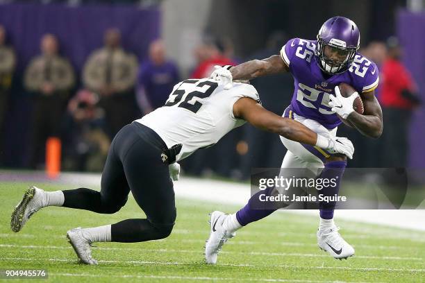 Latavius Murray of the Minnesota Vikings pushes off a tackle from Craig Robertson of the New Orleans Saints during the first half of the NFC...