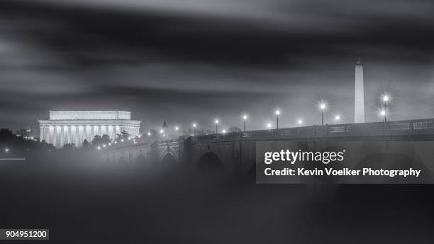 foggy potomac river with lincoln memorial and washington monument - arlington memorial bridge stockfoto's en -beelden