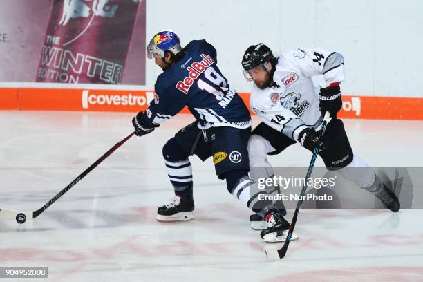 Tom Gilbert of Nuernberg Ice Tigers vies Jon Matsumoto of Red Bull Munich during 42th Gameday of German Ice Hockey League between Red Bull Munich and...