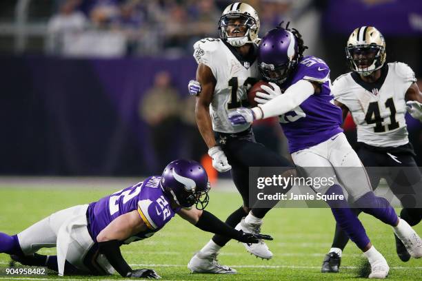 Emmanuel Lamur and Harrison Smith of the Minnesota Vikings tackles Michael Thomas of the New Orleans Saints during the first half of the NFC...