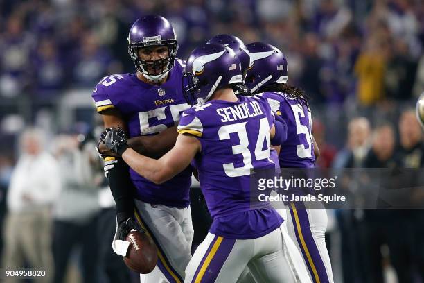 Anthony Barr of the Minnesota Vikings celebrates with Eric Kendricks and Andrew Sendejo after a interception against the New Orleans Saints during...