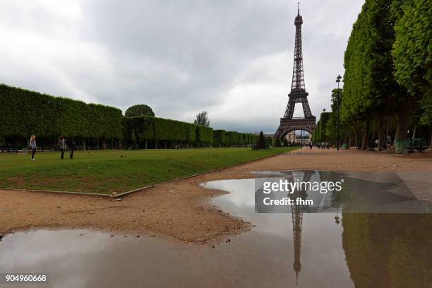 eiffel tower with reflection in a puddle, paris (france) - paris buildings reflect into puddles stockfoto's en -beelden
