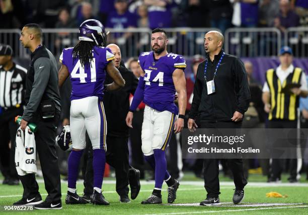 Andrew Sendejo of the Minnesota Vikings walks off the field with trainers after suffering an injury in the third quarter of the NFC Divisional...