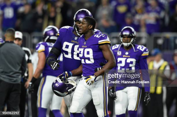 Linval Joseph of the Minnesota Vikings tries to hold back teammate Xavier Rhodes in the third quarter of the NFC Divisional Playoff game against the...