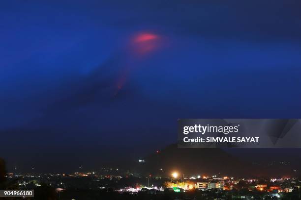 The glow of lava from the cloud-covered Mayon volcano as it erupts is pictured from the Philippine city of Legazpi in Albay province, early on...