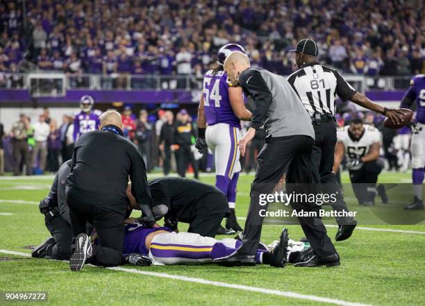 Andrew Sendejo of the Minnesota Vikings is evaluated by trainers on the field after suffering an injury in the third quarter of the NFC Divisional...