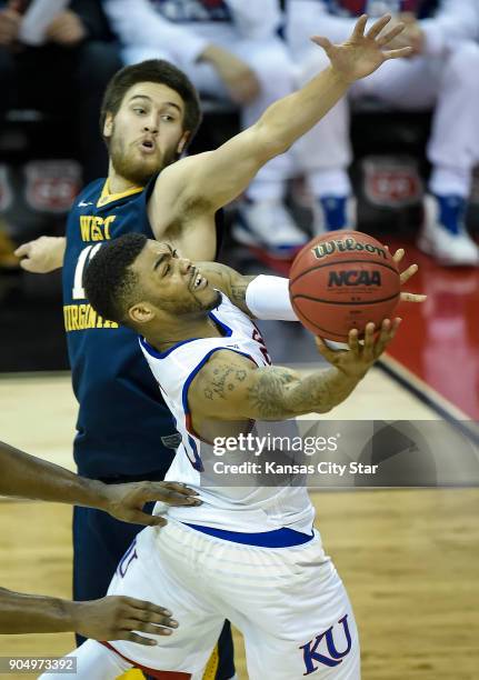 Kansas guard Frank Mason III drives to the basket past West Virginia forward Nathan Adrian in the second half on Saturday, March 12 during the...