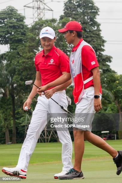 Li Haotong is smiling while having a conversation with his caddie at Eurasia Cup. EurAsia Cup is a biennial men professional team golf tournament...
