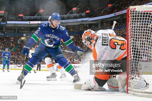 Ben Hutton of the Vancouver Canucks looks on as Brian Elliott of the Philadelphia Flyers makes a save during their NHL game at Rogers Arena December...