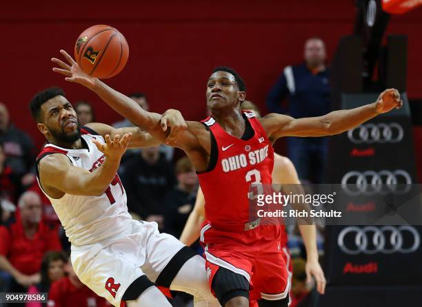 Jackson of the Ohio State Buckeyes reaches past Souf Mensah of the Rutgers Scarlet Knights for a loose ball during the second half of a game at...